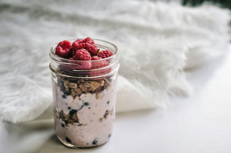 Parfait de coco fermentado con granola y frutos rojos en un tarro de cristal