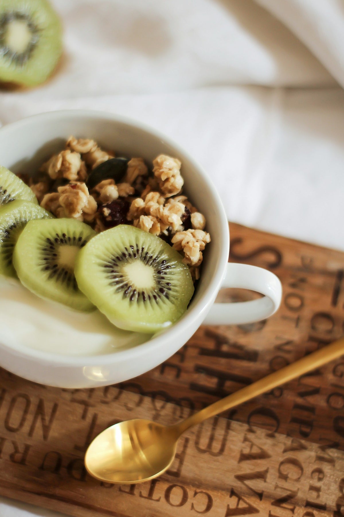 Coco fermentado con rodajas de kiwi y frutos secos en un cuenco blanco