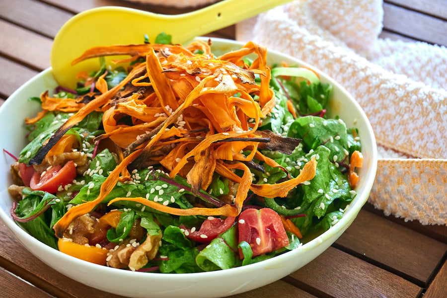 Bol de ensalada verde con zanahoria rallada y aguacate