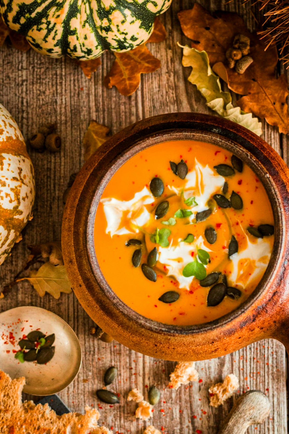 Crema de calabaza con un remolino de coco fermentado y pipas en un cuenco de barro